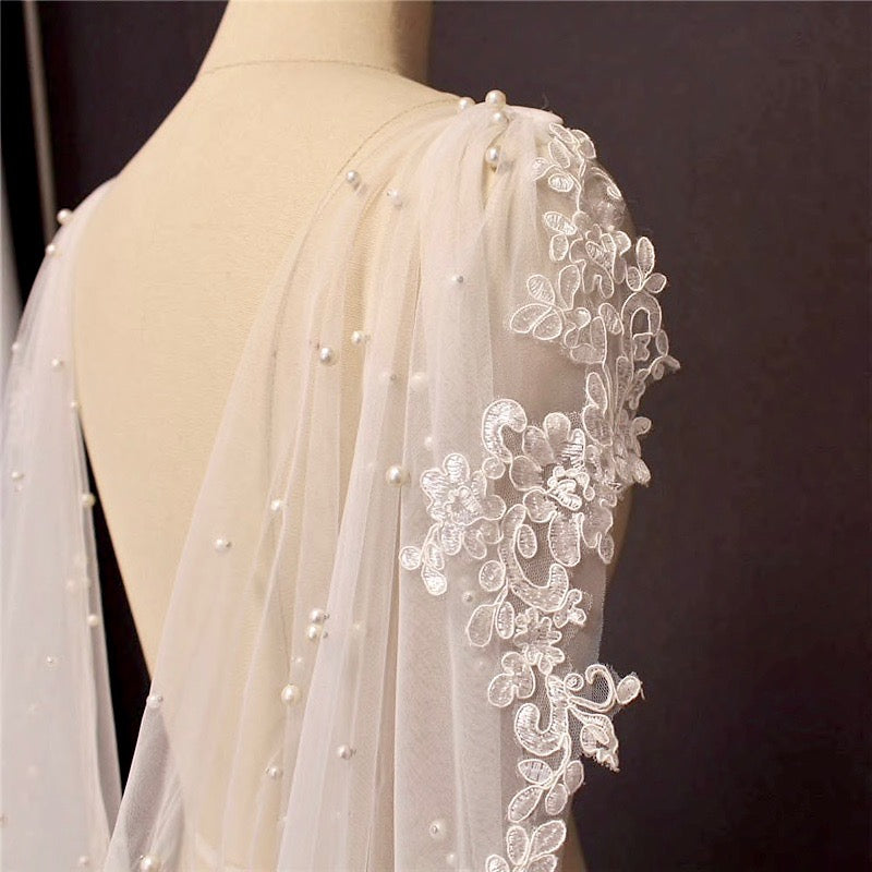 https://www.adorabysimona.com/cdn/shop/products/PearlWeddingCapeVeil2_1024x1024.jpg?v=1670113710